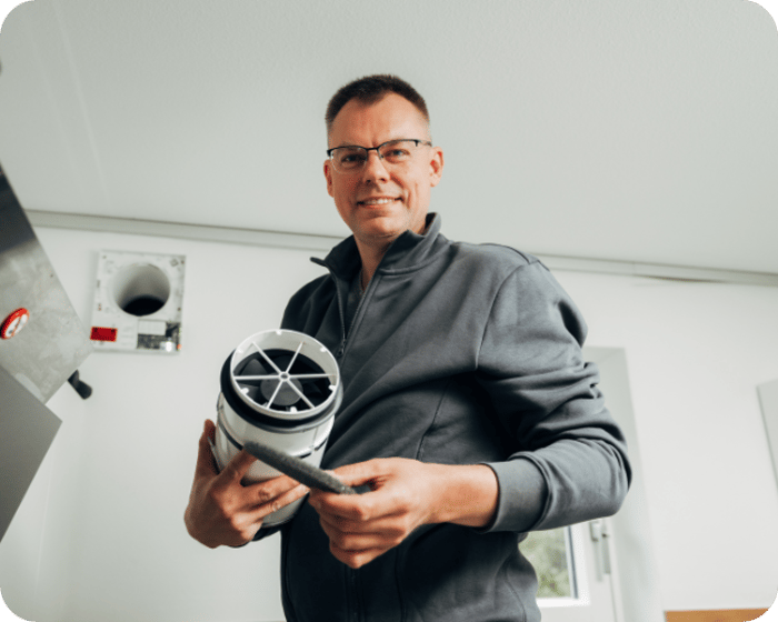 Remigijus Karalius mit dezentraler Lüftungsanlage in der Hand